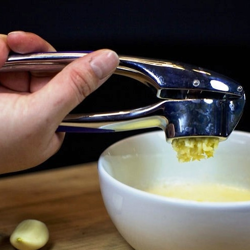 1. Этап. Соус для морепродуктов: Сливочное масло растапливаем в микроволновке, выдавливаем в него два зубчика чеснока.