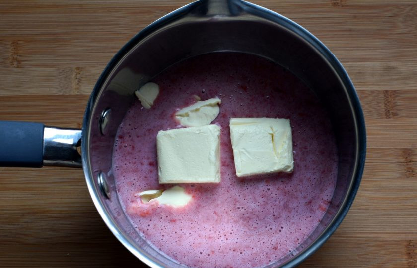 1. Этап. Эклеры Клубника со сливками: Отмеряйте в кастрюльку для теста 150 мл клубничного пюре, а также влейте молоко. Добавьте соль, масло и доведите массу до кипения.