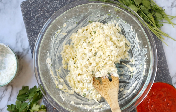 1. Этап. Сырная лазанья с томатным соусом: 1. Сделайте начинку. Натрите пармезан и моцареллу. Добавьте к ним творог, соль, перец. Мелко нарубите петрушку и чеснок. Все ингредиенты перемешайте.