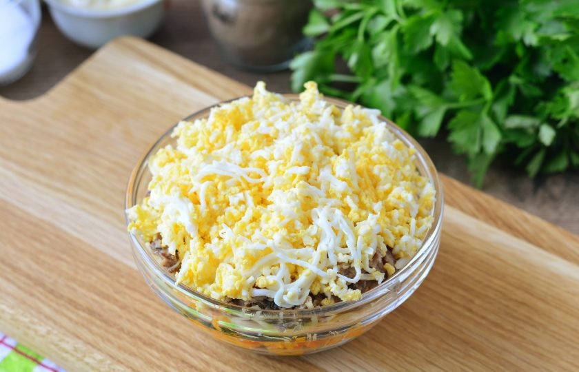 1. Этап. Салат с сайрой и грибами: В завершении присыпьте салат натертыми яйцами.