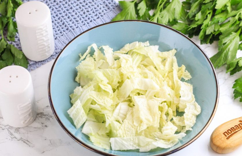 1. Этап. Салат с мидиями и помидорами: Промойте пекинскую капусту и нарежьте ее листовую не жесткую часть ломтиками или лентами, как вам больше нравится. Посолите нарезку и слегка перетрите руками в салатнике до мягкости.