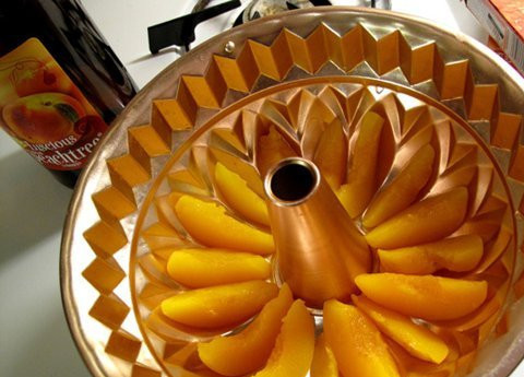 1. Этап. Желейный торт с фруктами: 1. На дно выбранной формы выложить дольки персиков. Для этих фруктов очень удобно использовать именно форму для кексов. Еще при приготовлении желейного торта с фруктами можно использовать сразу несколько видов фруктов и несколько слоев цветного желе, например.