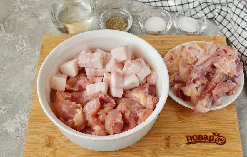 1. Этап. Домашняя колбаса из курицы: Подготовьте мясо и сало к измельчению. С мяса снимите кожу, удалите косточки, с сала снимите шкуру. Порежьте все кусочками.