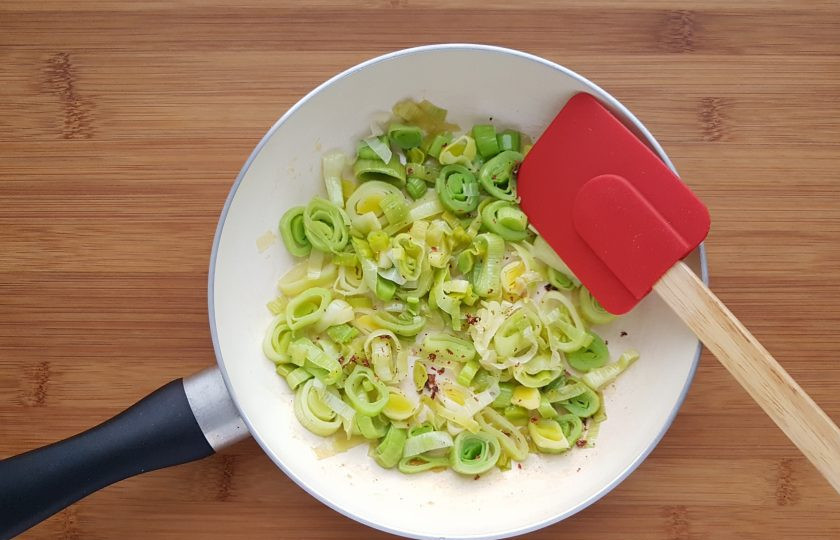 1. Этап. Рыбный пирог с тестом фило: Лук порей нарежьте колечками. На сковороде распустите столовую ложку сливочного масла и пассеруйте порей до мягкости. В конце приготовления посолите и поперчите.