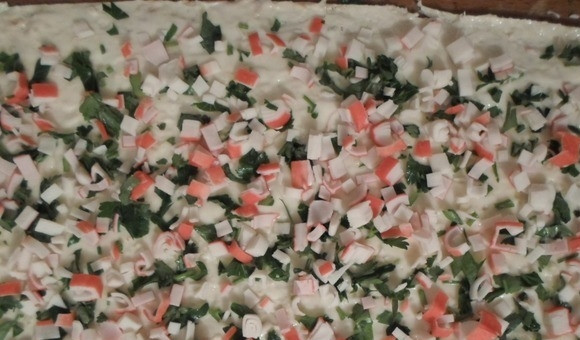 1. Этап. Обжаренный лаваш с крабовыми палочками: Один слой лаваша промажьте сыром. Сверху распределите зелень и крабовые палочки.