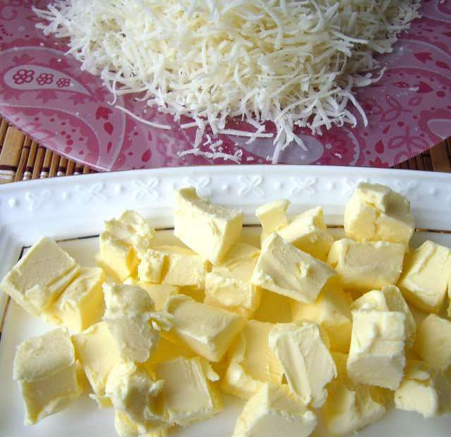 1. Этап. Ризотто с овощами и грибами: Снимаем ризотто с огня и даем ему постоять одну минуту. Тем временем, нарезаем кубиками сливочное масло и натираем на мелкой терке сыр.