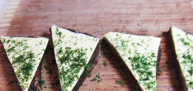 1. Этап. Закуска из черного хлеба с сельдью: Каждый ломоть разрезаем пополам по диагонали, присыпаем укропом.