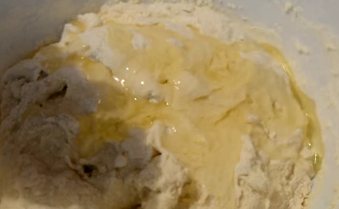 1. Этап. Жареные пирожки с капустой на кислом молоке: 4. Чтобы тесто меньше липло к рукам, добавьте подсолнечное масло. Присыпьте стол мукой и продолжите вымешивать тесто руками.
