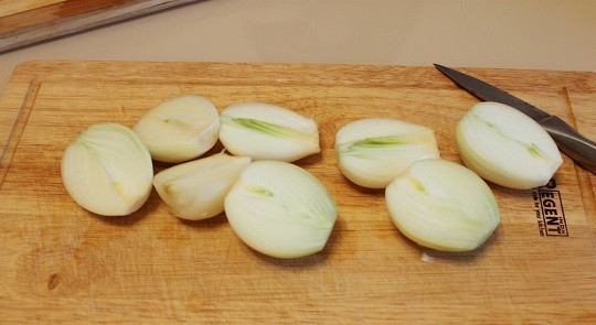 1. Этап. Гусь в гусятнице: 2. Очистите лук, нарежьте его крупными кусочками.