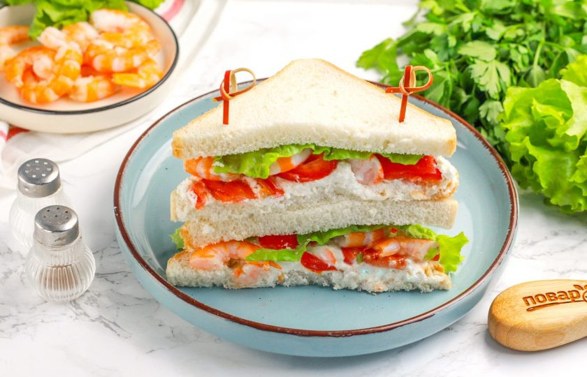1. Этап. Сэндвич с креветками: Острым ножом разрежьте сэндвич по диагонали и выложите одну половину на другую. Закрепите зубочистками и подайте к столу. Приятного вам аппетита!