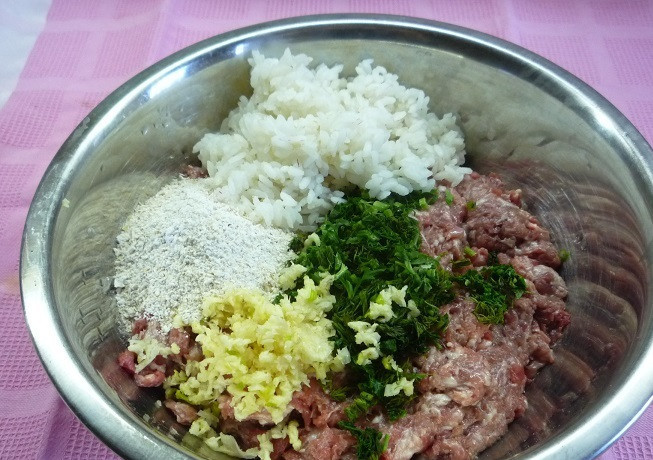 1. Этап. Биточки из фарша и риса: Для начала нам необходимо смешать в глубокой миске фарш, измельченные овсяные хлопья, предварительно отваренный рис, яйцо, пропущенный через пресс чеснок, а также измельченную зелень, специи и соль.