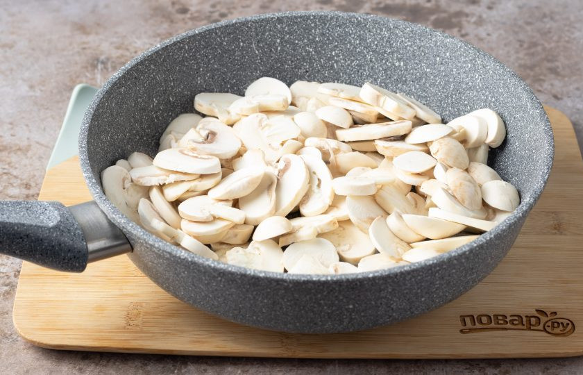 1. Этап. Жареные грибы с луком и морковью на сковороде: Разогрейте сковороду на среднем огне с растительным маслом. Добавьте шампиньоны, жарьте их на сильном огне, пока не выпарится влага, затем убавьте температуру и готовьте еще 2-3 минуты.