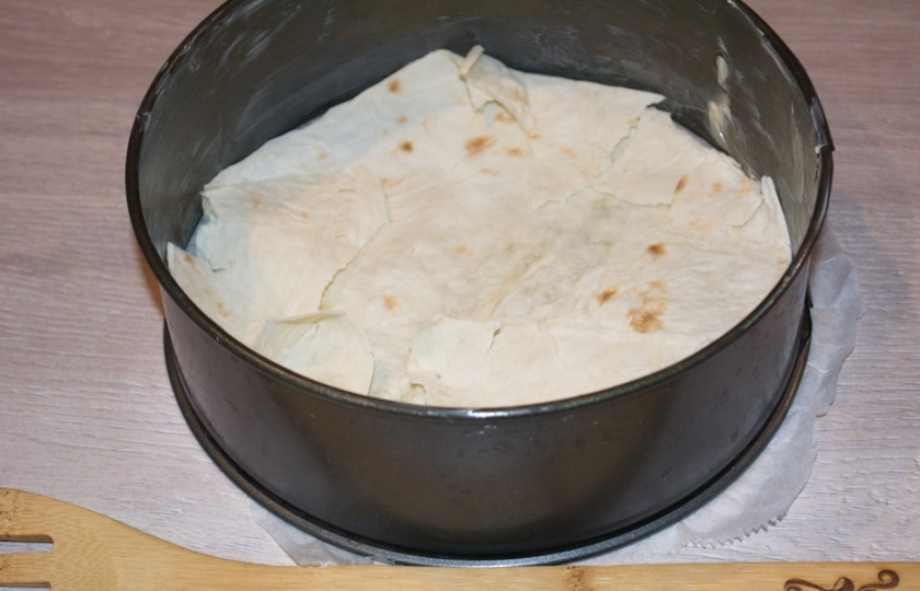 1. Этап. Слоеный яблочный пирог: Форму для запекания смажьте сливочным маслом. На дно формы выложите кусочки лаваша, застелив все дно формы.