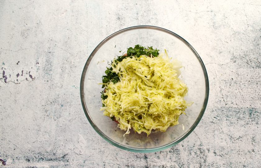 1. Этап. Пирожки с кабачком и фаршем: Кабачок очистите от кожуры и если есть семена, натрите на средней терке. Все посолите, поперчите и перемешайте.