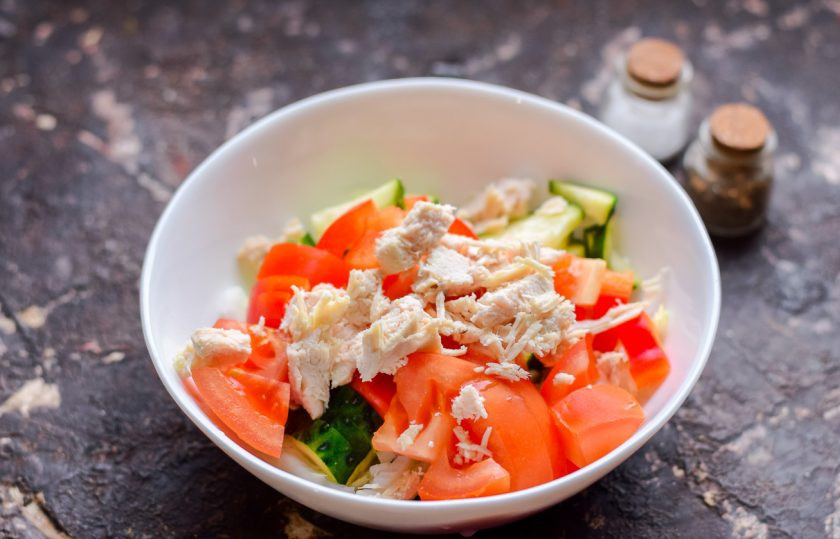 1. Этап. Салат Яркий праздник с курицей: Добавьте в овощи нарезанное куриное филе. Соль и перец добавьте в салат по своему вкусу.