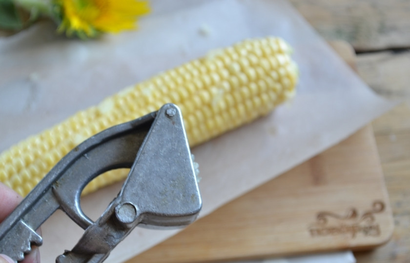 1. Этап. Запеченная молодая кукуруза: Кукурузу положите на подходящий по размеру лист пергамента и натрите пропущенным через пресс чесноком.