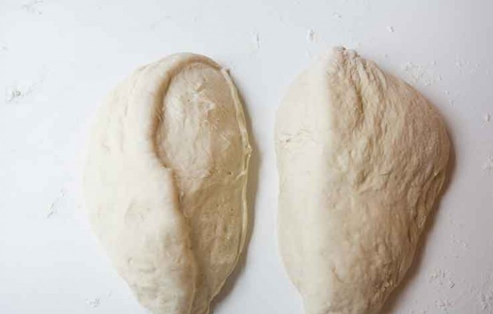 1. Этап. Хлеб из картофеля: 6. Выложите тесто на ровную, немного посыпанную мукой поверхность и замесите несколько раз, затем разрежьте тесто на два кусочка.