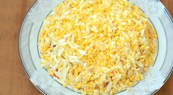 1. Этап. Слоеный салат с корейской морковью: Сверху натрите яйцо. Салат украсьте по желанию. Приятного аппетита!