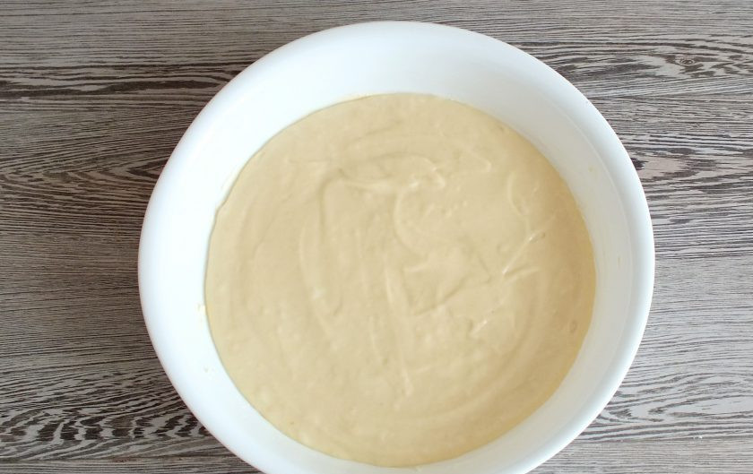 1. Этап. Ленивая ватрушка с творогом: Форму для выпечки смажьте сливочным маслом. Перелейте в неё подготовленное тесто.