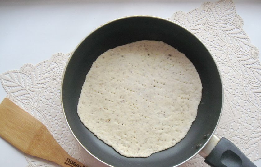 1. Этап. Сметанный торт с грецкими орехами: Кусочек теста раскатайте в тонкий пласт и выложите на сухую, горячую сковороду. Наколите вилкой. Диаметр моей сковороды 18 сантиметров.