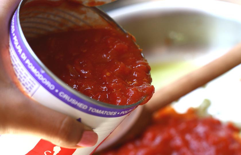 1. Этап. Соус томатный: 4. Затем в сковороду выложите консервированные помидоры с соком. Если они - целые, предварительно измельчите. Добавьте в сковороду.