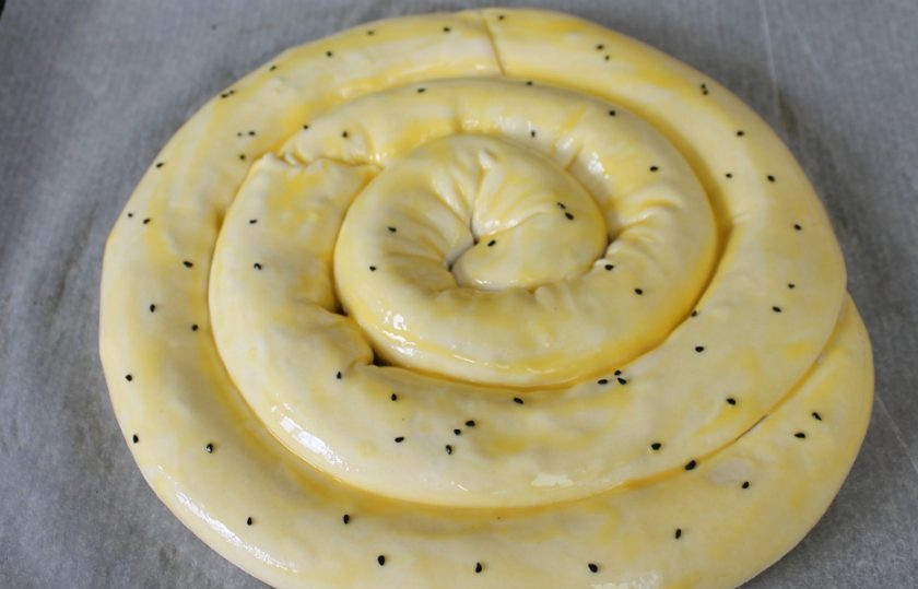 1. Этап. Греческая улитка: Смешаем желток и йогурт. Этой смесью смазываем улитку и посыпаем ее черным тмином. Запекаем при температуре 180 градусов около 40 минут. Должна быть включена функция 