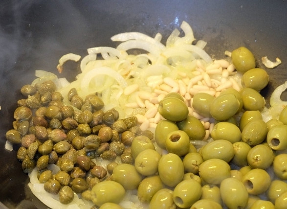 1. Этап. Овощи по-сицилийски с каперсами: 10. К луку добавляем оливки, каперсы и кедровые орешки. прожариваем пару минут при постоянном помешивании.