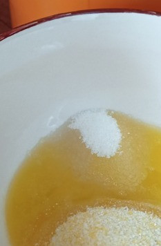 1. Этап. Безглютеновая творожная запеканка: Духовку включить нагреваться до 180С. Сливочное масло нарезать и растопить на малой мощности в микроволновке или на водяной бане. Добавить в растопленное масло поленту (или кукурузную манку) и сахар, перемешать.