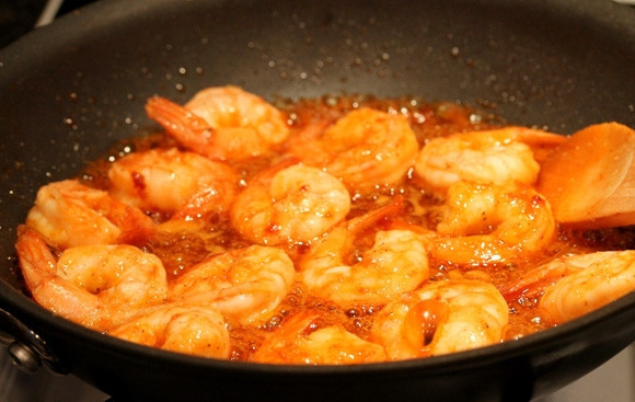 1. Этап. Салат с креветками: Влейте остро-сладкий соус к креветкам, когда они уже почти будут готовы. Обжарьте их, помешивая, в течение двух минут.