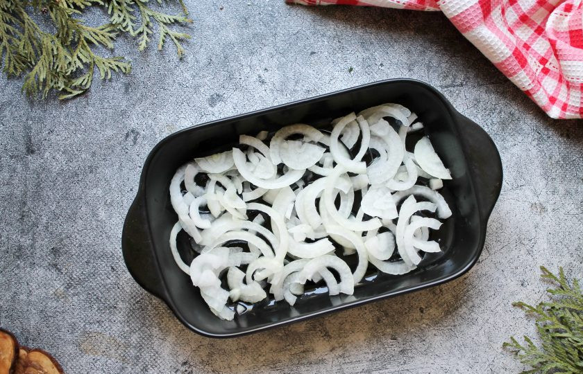 1. Этап. Салака в томате: Форму для запекания смажьте растительным маслом и выложите репчатый лук, порезанный полукольцами.