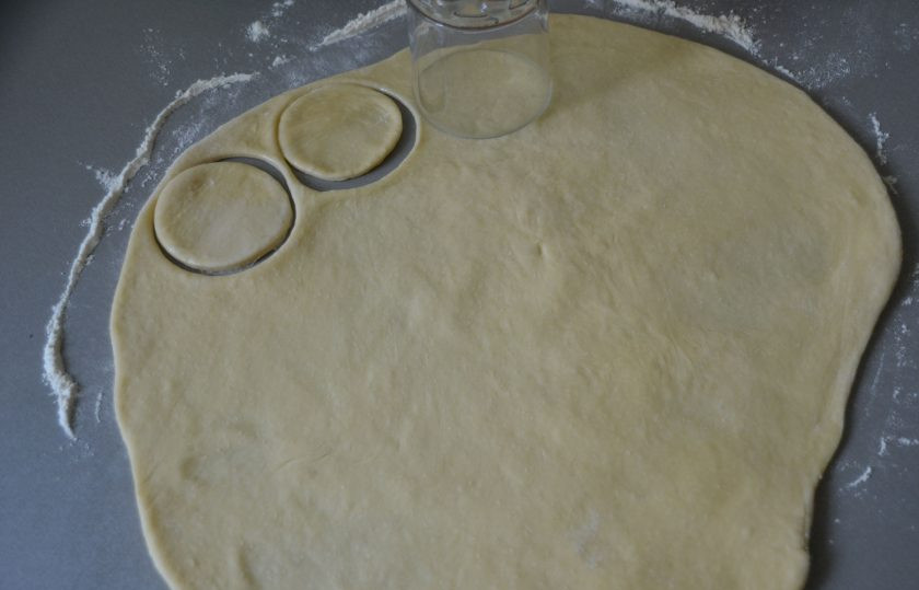 1. Этап. Воскресный пирог: Готовое тесто раскатайте на столе, присыпанным мукой в пласт, стаканом или другой выемкой для теста, вырежьте кружочки диаметром примерно 8 см.