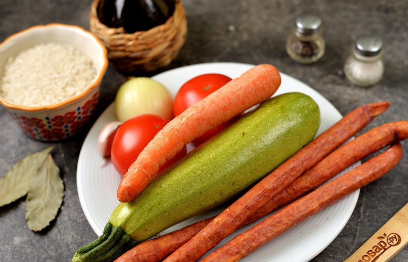 1. Этап. Рис с колбасками и овощами: Подготовьте все ингредиенты. Лук, чеснок и морковь почистите, помойте вместе с помидорами и обсушите.