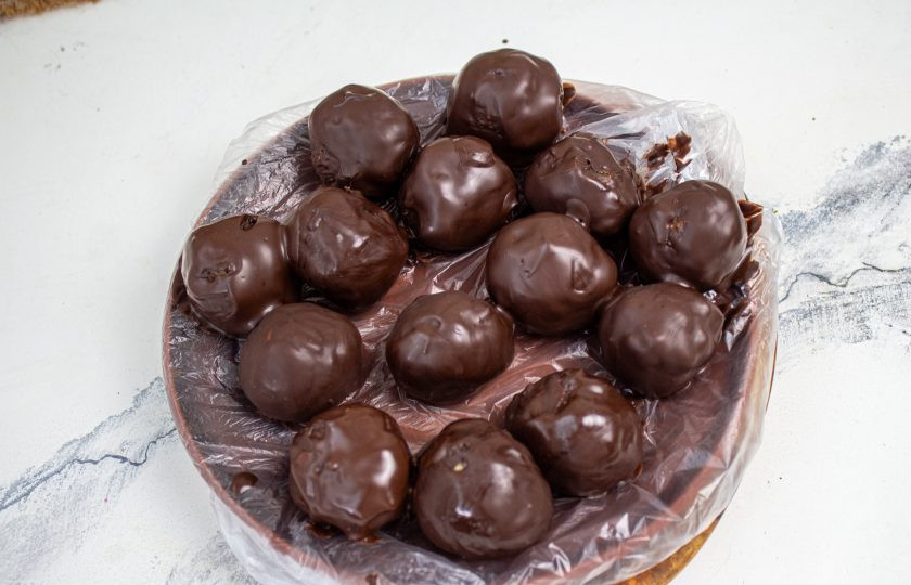 1. Этап. Конфеты из сухофруктов в шоколаде: Дайте стечь лишнему шоколаду и переложите на блюдо, выстеленное пленкой. Уберите в холодильник на минут 30, до застывания шоколада.