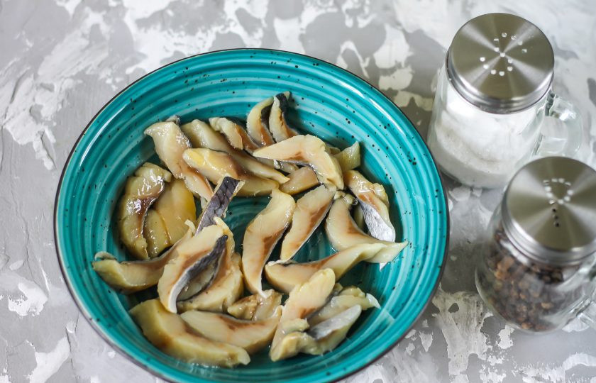 1. Этап. Салат из селедки с морковью: В салатник или миску выложите кусочки слабосоленой сельди из пресервы. По желанию можно отфилетировать соленую сельдь, удалить косточки и нарезать филе ломтиками, выкладывая его в емкость.