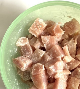 1. Этап. Куриное филе с брокколи и булгуром: Куриное мясо нарезать кубиками, посолить и добавить крахмал, хорошо перемешать.