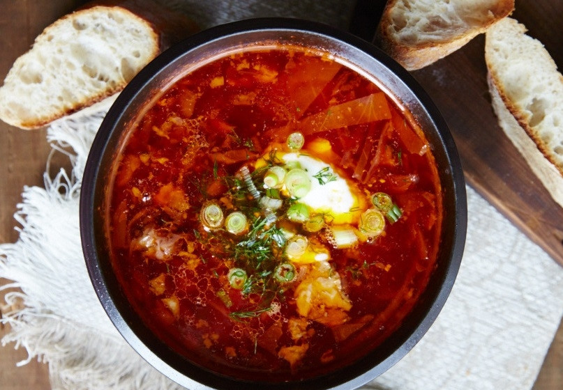 1. Этап. Настоящий украинский борщ: 7. Пропустите чеснок через пресс и добавьте в кастрюлю, по вкусу посолите и поперчите. Выключите огонь и настаивайте блюдо 20 минут. Подавайте борщ с зеленью и ложкой сметаны.