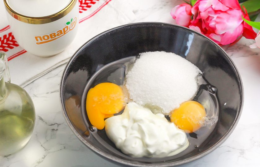 1. Этап. Творожные кексы в аэрогриле: Вбейте в глубокую емкость куриные яйца, выложите сметану любой жирности, всыпьте соль и сахар. Можно добавить пару щепоток ванильного сахара или немного ванильного экстракта. Взбейте все венчиком примерно 2-3 минуты.