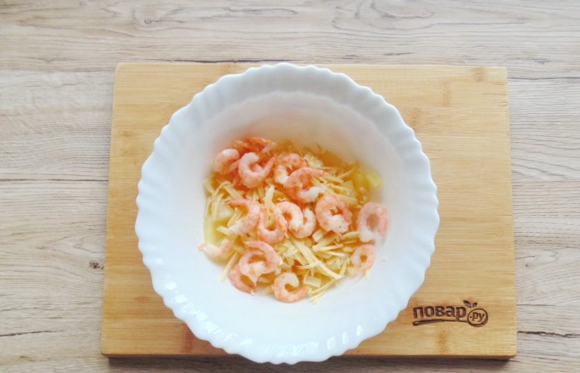 1. Этап. Салат из ананасов с чесноком и сыром: Креветки обдайте кипятком, очистите и выложите в салатник.