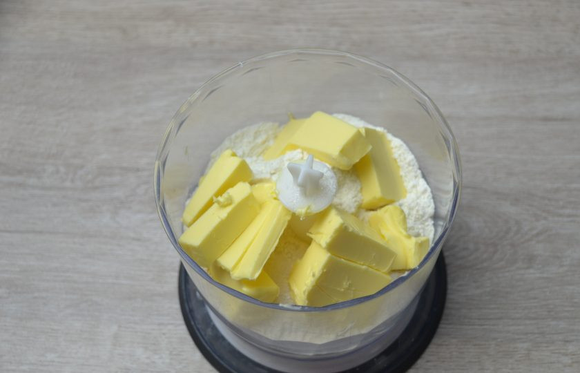 1. Этап. Американский лимонный пирог: Выложите в чашу блендера муку, 115 грамм холодного сливочного масла, соль, сахар, все смешайте до состояния крошки.