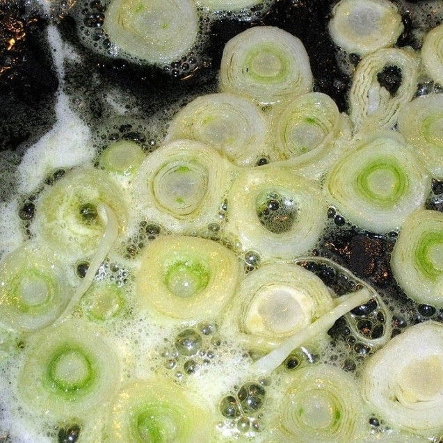 1. Этап. Ризотто с миндалем: Миндаль необходимо прокалить на сухой сковороде, затем залить на 10 минут кипяченой водой и очистить. Тем временем обжарим в сливочном масле нарезанный тонкими колечками лук-порей.