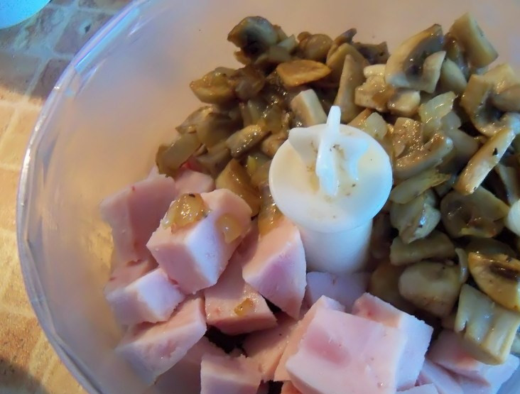 1. Этап. Вкусные бутерброды: Положите в кухонный комбайн нарезанное куриное сердце, измельченные соленый огурец, ветчину, жареные грибы и лук.