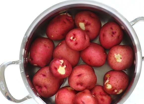 1. Этап. Деревенский картофельный салат: 1. Тщательно промойте картофель, положите его в кастрюлю, залейте водой, чтобы весь картофель был покрыт, посолите. Накройте крышкой и доведите до кипения, варите на сильном огне 15 минут, пока картофель не станет мягким при прокалывании. Слейте воду и немного остудите картофель.