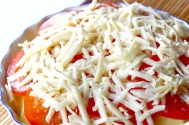 1. Этап. Картофельная запеканка с помидорами и сыром: Сыр натираем на крупной терке, посыпаем им помидоры.