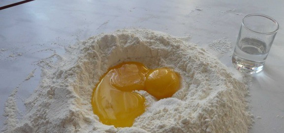 1. Этап. Чак-чак с медом: В муку кладем три желтка, соль и ложку водки. Тщательно все перемешиваем. Затем добавляем два белка.