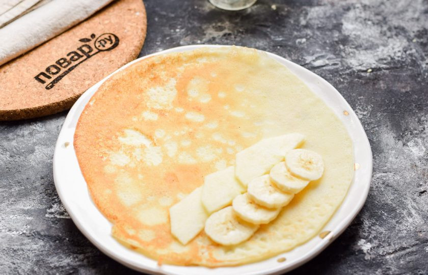 1. Этап. Блинчики с яблоком и бананом: На край блинчика выложите яблоки и банан, после сверните рулетиком.