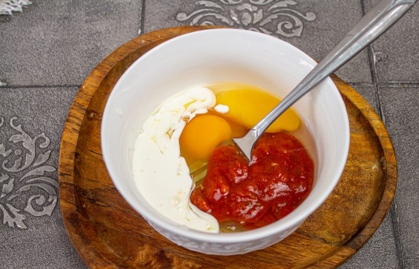 1. Этап. Трёхслойный торт-омлет: Для третьего омлета соедините 2 яйца, 1 столовую ложку сливок и 1 столовую ложку кетчупа. Приправьте по вкусу.