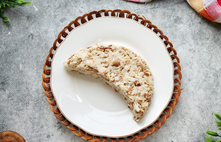 1. Этап. Салат Арбузная долька с курицей и грибами: На сервировочное блюдо переложите салат и сформируйте плотный полукруг.