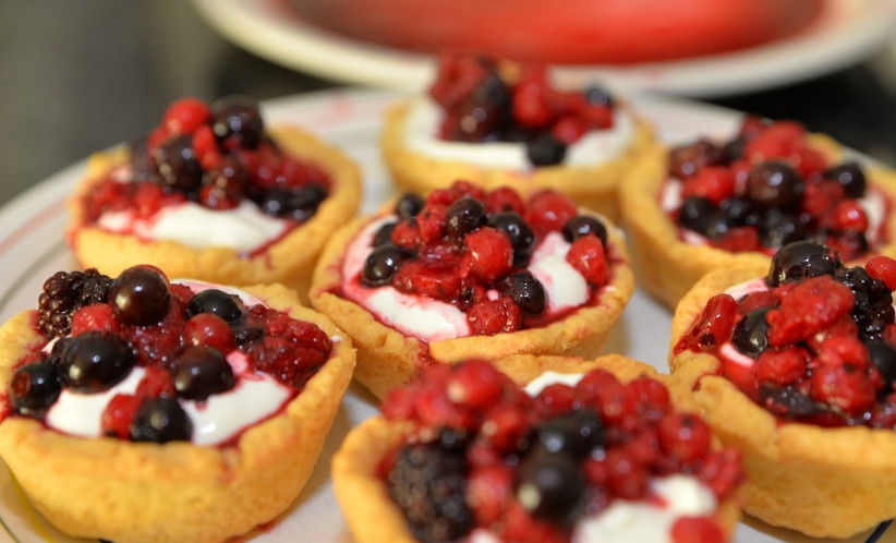 1. Этап. Тарталетки в духовке с начинкой: Выкладываем крем в остывшие тарталетки. Украшаем выпечку размороженными ягодами. Приятного аппетита!