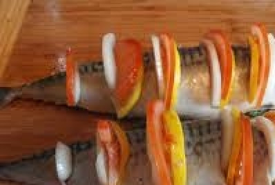 1. Этап. Скумбрия в фольге: На спинке скумбрии сделайте неглубокие разрезы и вставьте кольца лука, помидора и лимона. Зеленью наполните брюшко рыбы.