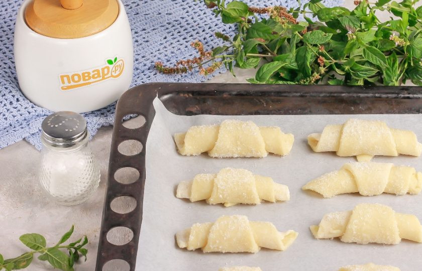 1. Этап. Творожные рогалики Нежнее нежного: Разогрейте духовку до 180 градусов. Застелите противень пекарской бумагой и выложите на нее заготовки на равном расстоянии друг от друга. Отправьте противень в духовку на 15 минут.